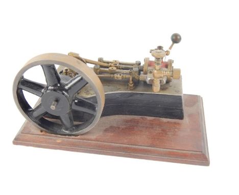 A partial horsepower live steam table top stationary engine, with 12cm dia. drive wheel and articulated piston top, on shaped