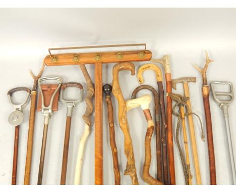 Wooden walking sticks, some with antler or horn handles, shooting sticks, riding crops, a pick axe, and a wooden lights stick