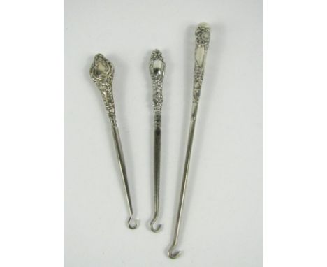 Three late Victorian/Edwardian steel button hooks, one with hallmarked silver handle and two unmarked.