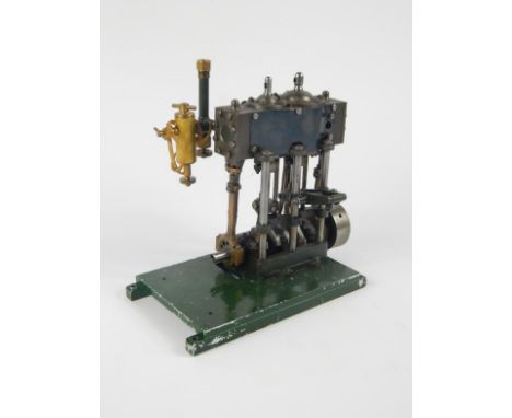 A scratch built table top vertical engine, with moving pistons and articulated sections on a plain green metal base, 21cm wid