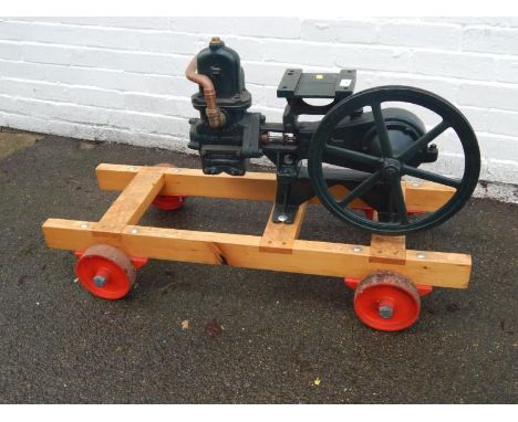 A mid-20thC Lee Howl Super Major stationary engine water pump, with 38cm dia. drive wheel, partially painted in green, on tru