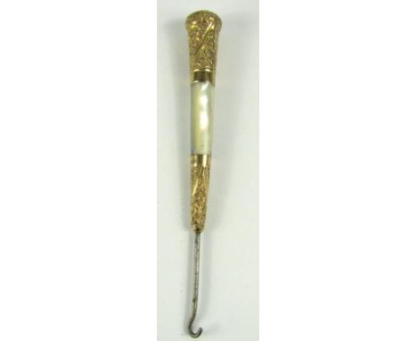 A late Victorian button hook, the tapered handle with mother of pearl and 18 gold plated mounts of foliate scroll design.