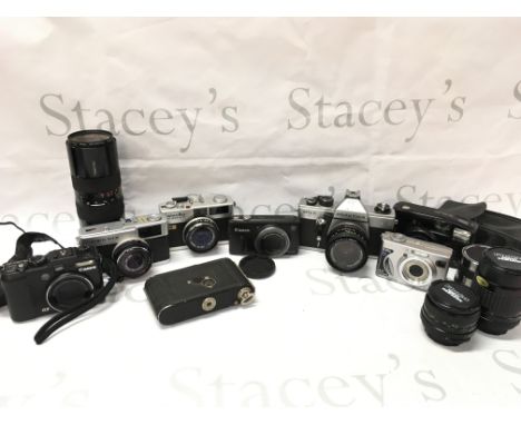A collection of vintage and modern cameras including A Canon G9, Canon SX 260 HS, Olympus trip 35, Praktica MLT 5, Minolta Hi