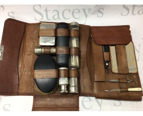 A vanity case containing glass jars, brush, razor etc together with a silver hand mirror