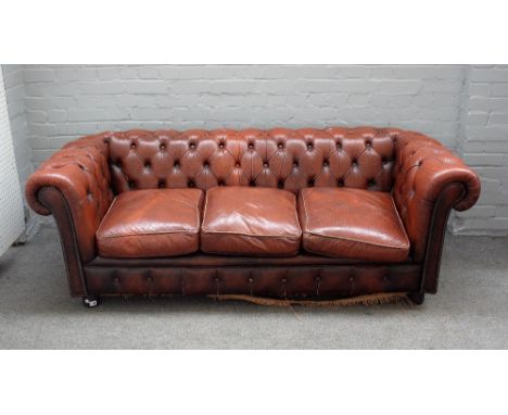 A 20th century button back brown leather upholstered Chesterfield sofa, on turned feet, 195cm wide x 67cm high.