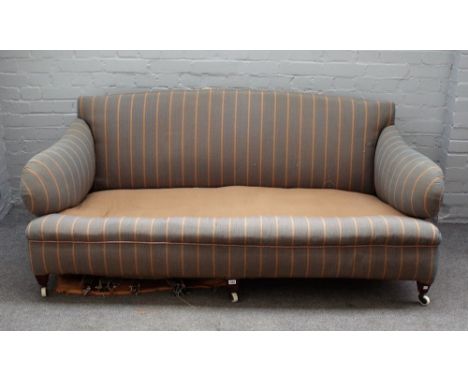 An early 20th century Howard style sofa with shaped arms and sides on tapering square walnut supports, 175cm wide x 77cm high