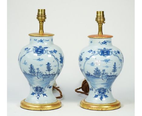 A pair of Dutch Delft blue table lamp vases, each decorated with a female figure in a landscape against a baluster ground wit
