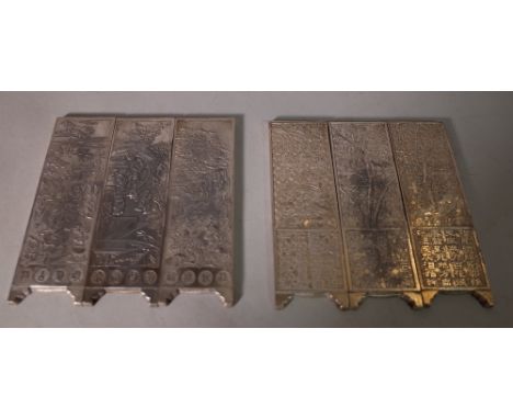 A set of three 20th century Chinese white metal scroll weights, framed as screen panels, 5cm wide x 15cm long and another set