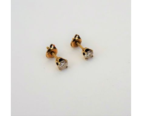 A pair of gold and diamond single stone earstuds, each claw set with a circular cut diamond, the backs with screw post and bu