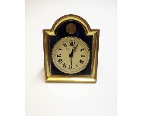A Swiss gilt metal and simulated lapis lazuli keyless wind alarm clock, the circular cream coloured dial with black Roman num
