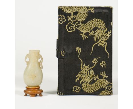 A miniature jade vase, 19th/20th century, of pear shape with elephant mask and ring handles, 3cm. high, wood stand and box.