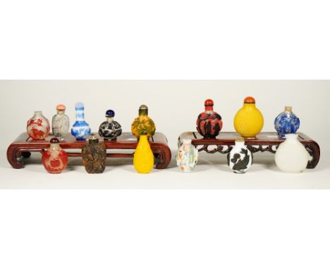 A group of fourteen Chinese snuff bottles, 20th century, including eight glass overlay examples, two yellow glass bottles, an