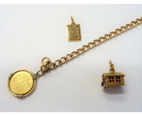 A gold curb link bracelet detailed 14 KT, on a boltring clasp, with a gold pendant medallion, detailed 14 K and two gold char