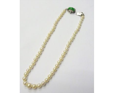 A single row necklace of graduated cultured pearls, on a white gold, jade and diamond set clasp, detailed 18 K, length  inclu