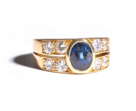 A gold, sapphire and diamond ring, collet set with the oval cut sapphire to the centre and with two pairs of circular cut dia