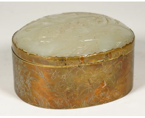 A Chinese jade mounted gilt-metal oblong jewel box, late 19th/early 20th century, the hinged cover inset with a pale celadon 