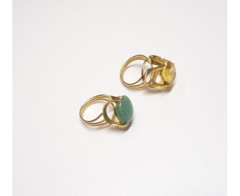 A gold ring, claw set with an oval cut citrine, in a raised design, ring size K and a gold ring, claw set with an oval caboch