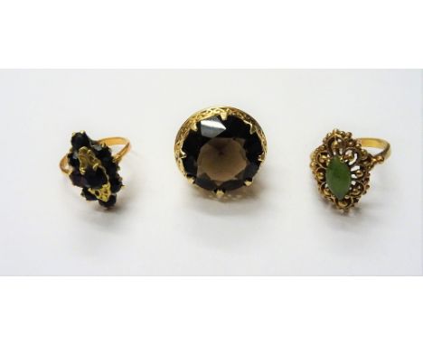 A gold ring, claw set with a circular cut smoky quartz, detailed 14 K and two further gold and gem set rings, (3).