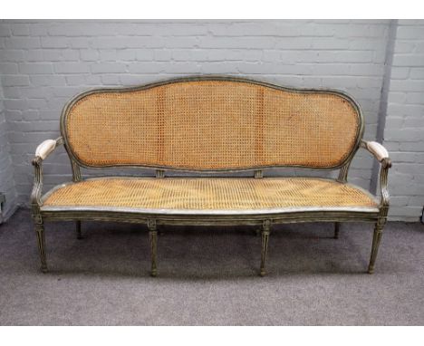 A Louis XVI style open arm sofa with distressed green/ grey painted frame and serpentine seat, on tapering fluted supports, 1