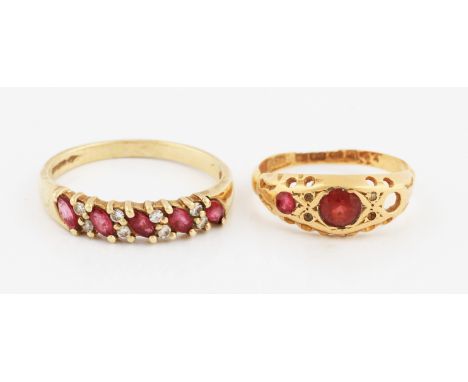 An 18ct yellow gold three stone ring, centrally set with a round cut garnet, flanked to one side with a round cut red paste a