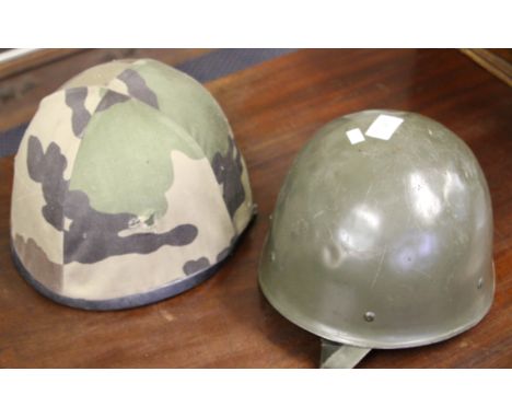 A French paratrooper helmet with camo cover, dated 1987, together with another similar green, dated 1973.