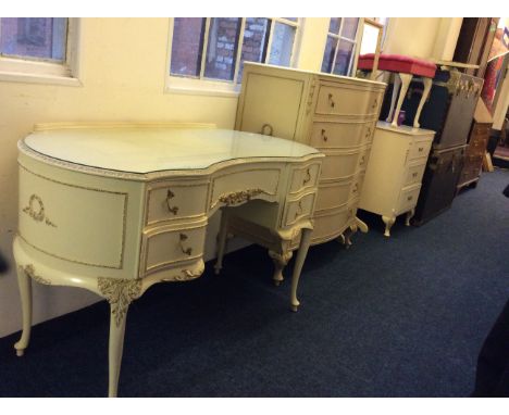 A five piece cream and gilt bedroom suite comprising of a dressing table, five drawer chest, floor standing mirror, dressing 