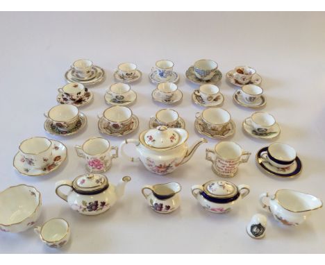 A selection of various miniature cups and saucers and two teapots with cream jugs including Coalport, Royal Corwn Derby etc.