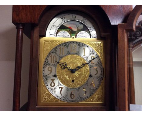 A reproduction mahogany grandfather automaton clock with brass face.