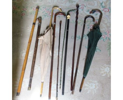 Two early 20th century parasols, one having a handle modelled as a ducks head, together with a shooting stick and assorted fu