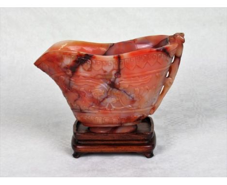 A large Chinese jade libation cup, the handled formed as a stylized big cat, the relief carved decoration depicting birds and