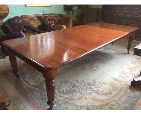 A large Victorian extending mahogany dining table, having three central leaves on fluted and turned supports, 295cm x 131cm. 