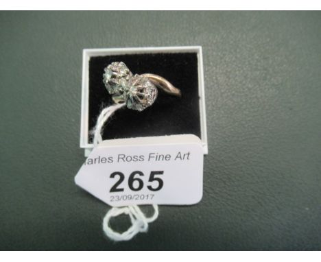 A diamond cluster crossover ring, the mix cut diamond clusters with central diamonds in raised claw mounts to plain shank.