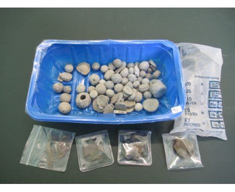 A mixed lot to include: arrow heads, a military uniform badge, stone tokens and other items.
