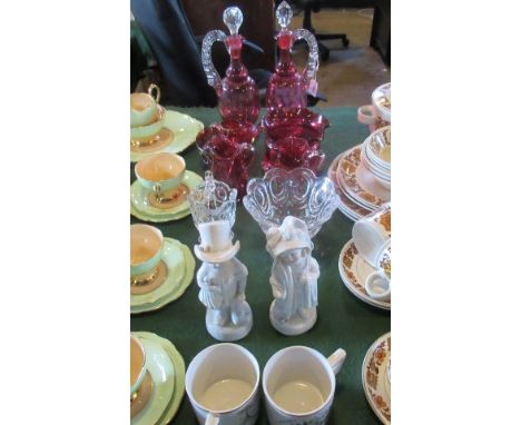 A pair of cranberry and clear glass single handled decanters and stoppers, together with five further items of cranberry glas