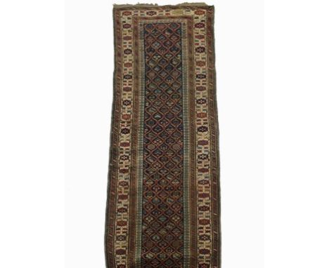 A PERSIAN RUNNER with a central long panel worked with geometric flowers within foliate compartments, within a multiguard bor