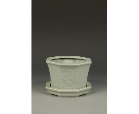 A CHINESE LONGQUAN STYLE CELADON JARDINIERE AND STAND of octagonal form, the body with alternating panels of flowers and call