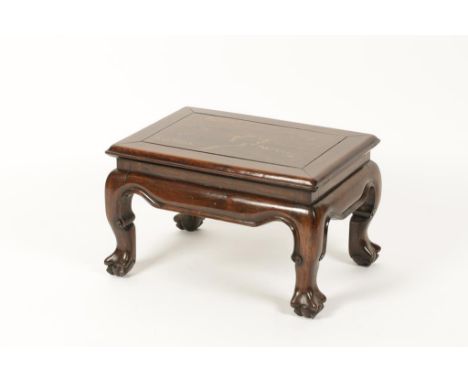 A CHINESE HARDWOOD LOW TABLE, the rectangular top with a moulded edge and central panel above a swept border and short cabrio