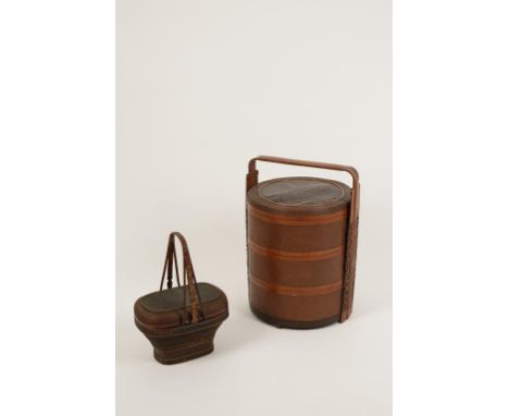 TWO CHINESE WICKER PICNIC BASKETS, the largest of cylindrical form, 23.5" high; the smaller basket of rounded rectangular for