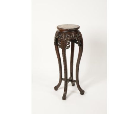 A CHINESE HARDWOOD MARBLE TOPPED STAND, the circular top with central marble panel on an outswept foliate carved border on ca
