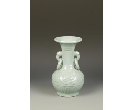 A CHINESE CELADON BALUSTER VASE, with mask and ring handles, the rounded body moulded with flowers above a lappet band, 20th 