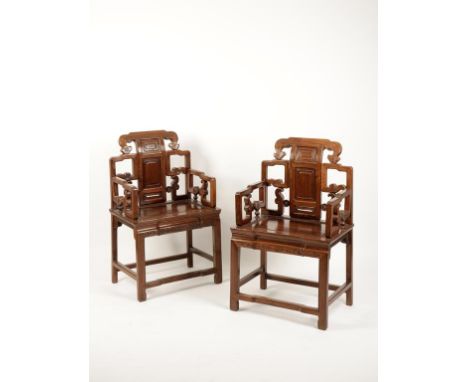 A PAIR OF CHINESE HARDWOOD OPEN ARMCHAIRS, probably hongmu, the back and arms of scroll form, above the panelled seat, late Q