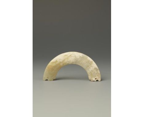 A CHINESE CALCIFIED CELADON JADE ARC-SHAPED PENDANT SECTION, carved with archaic dragon scrolls, probably Western Zhou, 3 1/4