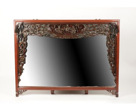 A LARGE CHINESE WALL MIRROR, the broad rectangular plate within a red stained and moulded surround with carved and pierced bo