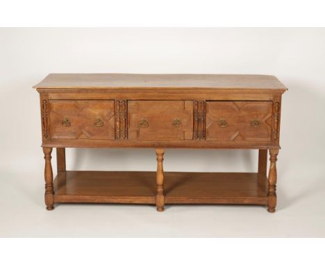 A LIGHT OAK DRESSER BASE, the rectangular top above three drawers with moulded fronts, with semi-circular turned divisions, a