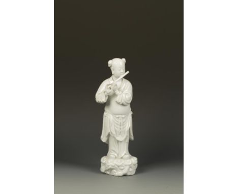 A CHINESE BLANC-DE-CHINE IMMORTAL, playing a flute and standing on a rocky base, seal mark on the back, late Qing-Republic, 1