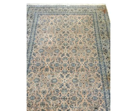 A PERSIAN RUG worked with a central panel of stylised foliage against a faded salmon ground within a multi guard border 