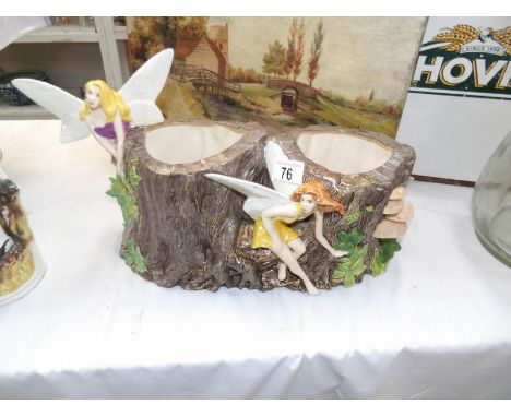 A pottery planter with fairy figurines and woodland decoration