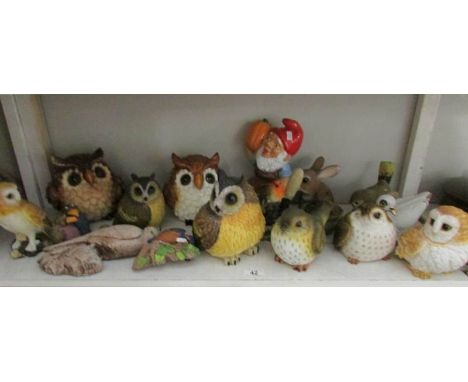 A shelf of owl figures, garden figures etc