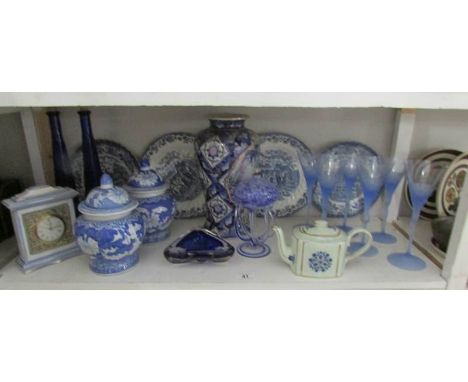 A shelf of miscellaneous items including glasses, blue and white etc
