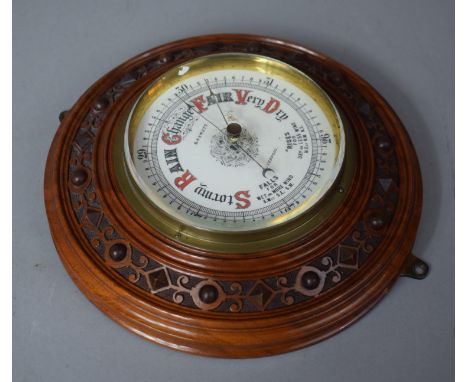 An Edwardian Carved Walnut Circular Aneroid Barometer by Basnett, Liverpool, 22cms Diameter 